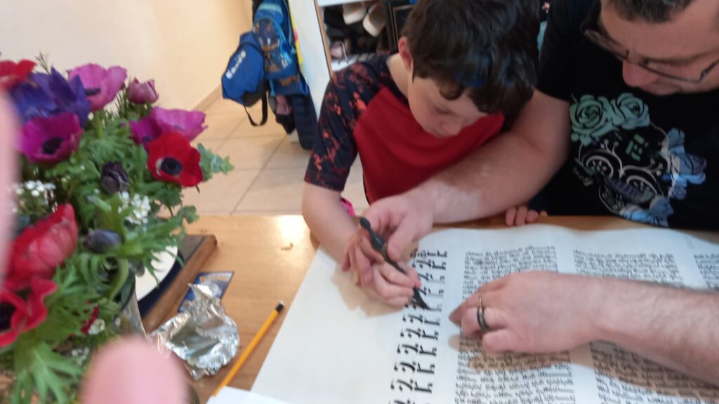 Gedalyah Reback showing his son how to use a qulmus/quill when writing a Megillat Esther